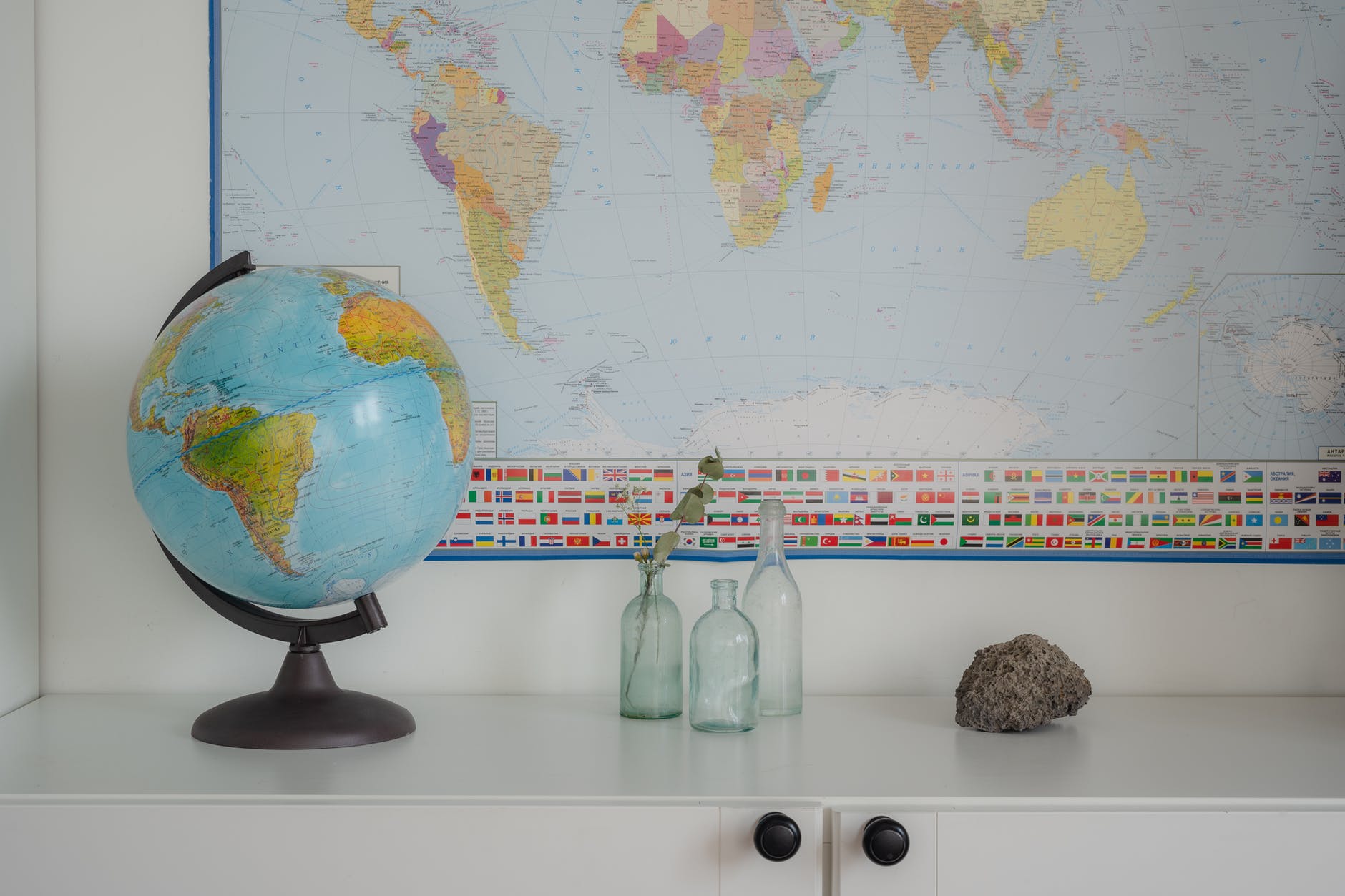 globe clear bottles and rock on white surface